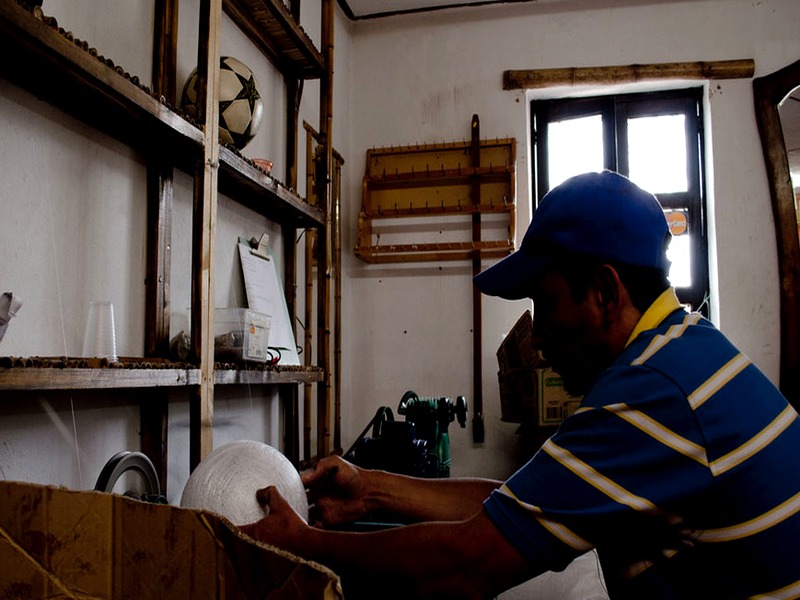 Artesano tensando cascos de cuero para ensamblar el balón